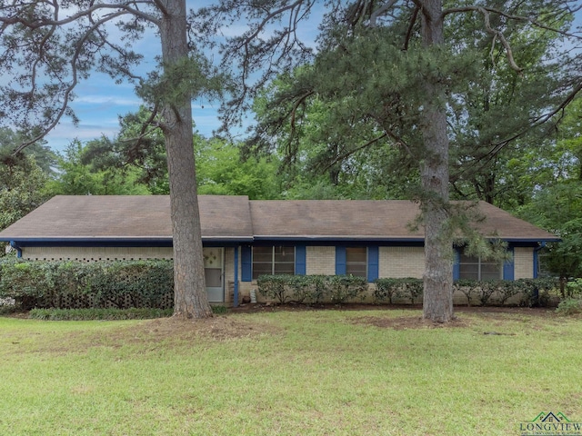 ranch-style home featuring brick siding and a front lawn