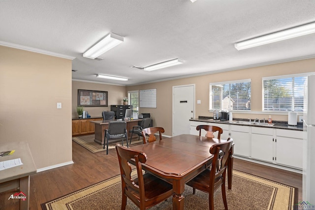 dining room with a textured ceiling, dark hardwood / wood-style floors, and ornamental molding