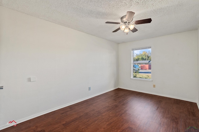 empty room with ceiling fan, dark hardwood / wood-style flooring, and a textured ceiling