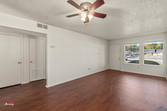 unfurnished room featuring a textured ceiling, ceiling fan, and dark wood-type flooring