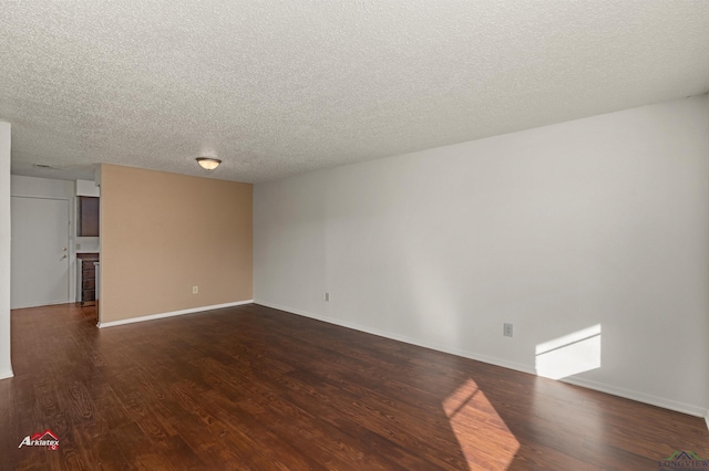 spare room featuring dark hardwood / wood-style flooring and a textured ceiling