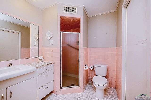604 Woodcrest Ln, Longview, TX 75601 - bathroom featuring tile walls, toilet, vanity, crown molding, and a stall shower