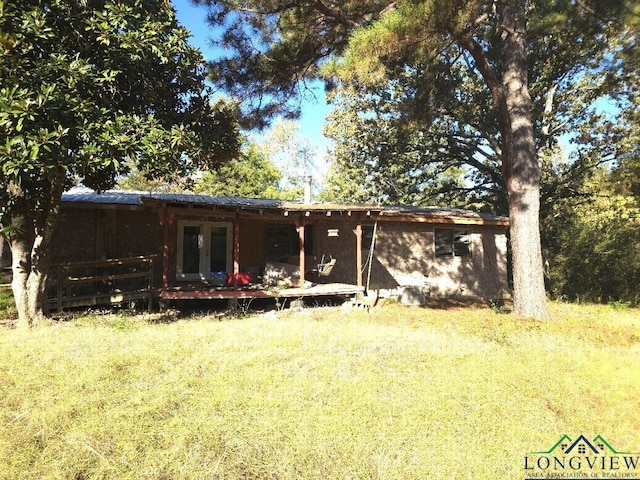 rear view of property with a lawn and french doors