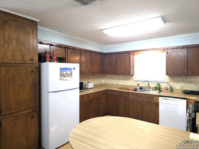 kitchen featuring a textured ceiling, white appliances, dark brown cabinets, and sink