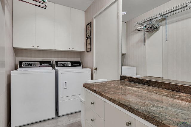 laundry area featuring cabinet space, light tile patterned flooring, and washer and dryer