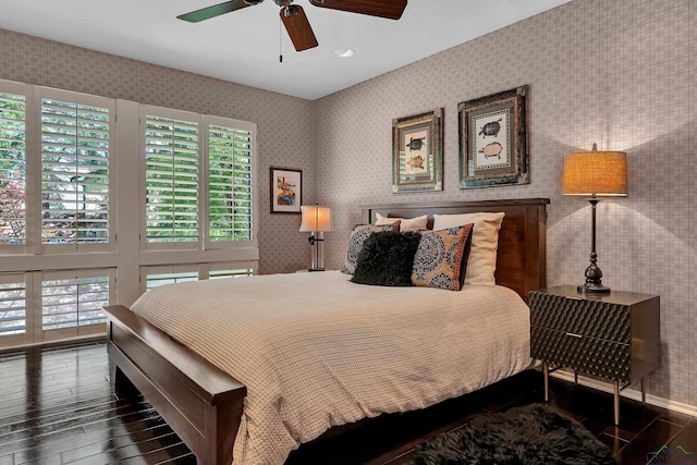 bedroom featuring baseboards, a ceiling fan, wood finished floors, and wallpapered walls