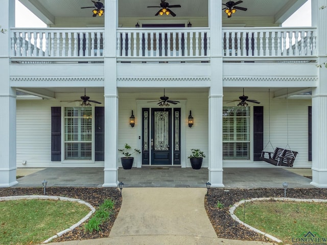 property entrance with a balcony and ceiling fan