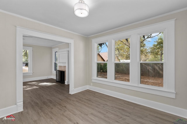 unfurnished living room with ornamental molding, dark hardwood / wood-style flooring, and a healthy amount of sunlight