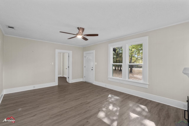 unfurnished room with a textured ceiling, dark wood-type flooring, ceiling fan, and ornamental molding