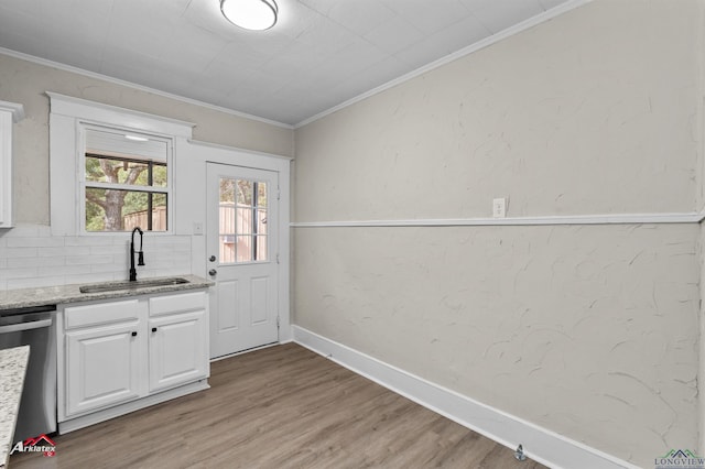 kitchen with white cabinetry, dishwasher, sink, tasteful backsplash, and crown molding