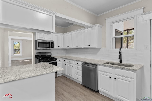 kitchen featuring decorative backsplash, appliances with stainless steel finishes, white cabinetry, and sink