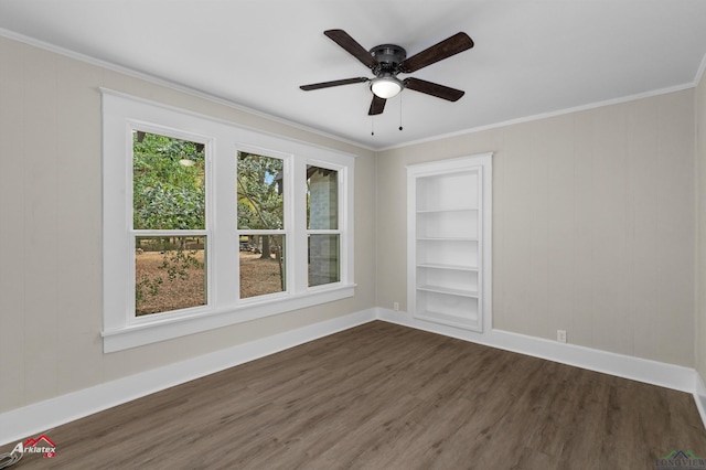 empty room featuring ceiling fan, dark hardwood / wood-style flooring, built in features, and ornamental molding