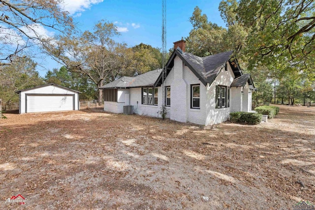 view of property exterior with central air condition unit, an outdoor structure, and a garage