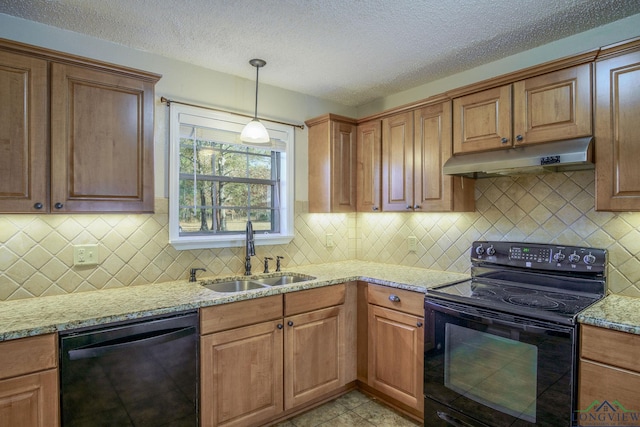 kitchen with black appliances, sink, hanging light fixtures, a textured ceiling, and light stone counters