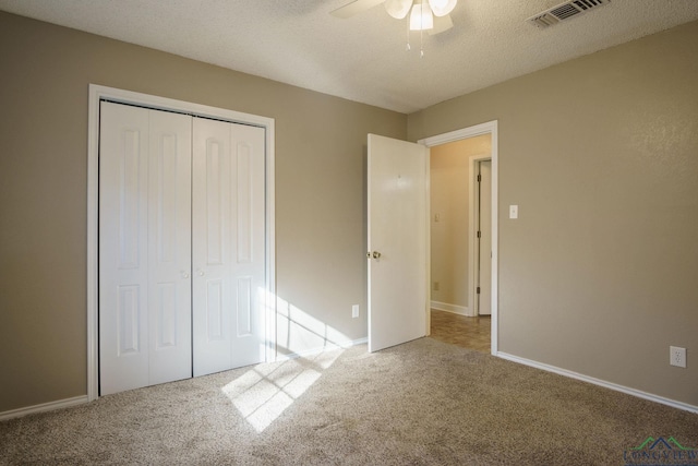 unfurnished bedroom featuring ceiling fan, a closet, carpet, and a textured ceiling