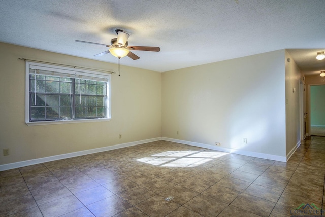 tiled spare room with ceiling fan and a textured ceiling