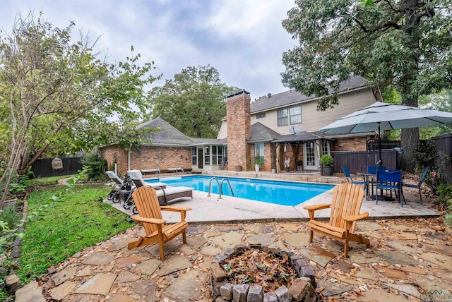 view of swimming pool with a fire pit and a patio