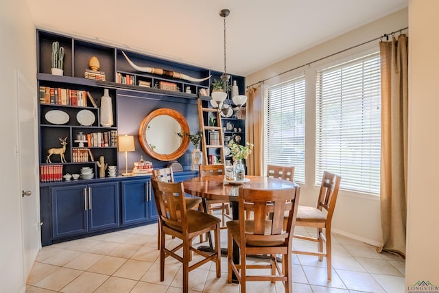 tiled dining room featuring a notable chandelier and a healthy amount of sunlight