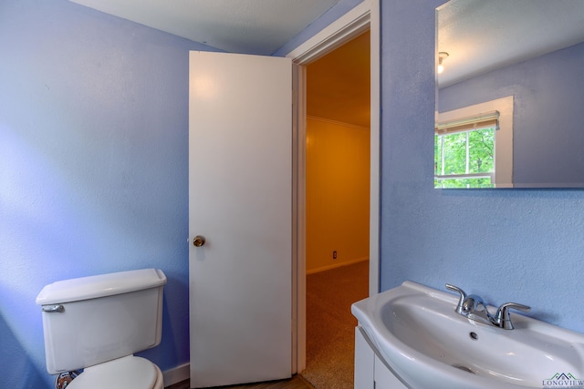 215 S Sidney St, Longview, TX 75602 - bathroom featuring toilet, vanity, and a textured wall