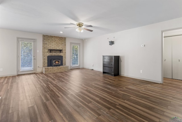 unfurnished living room with a wealth of natural light, ceiling fan, and dark hardwood / wood-style floors