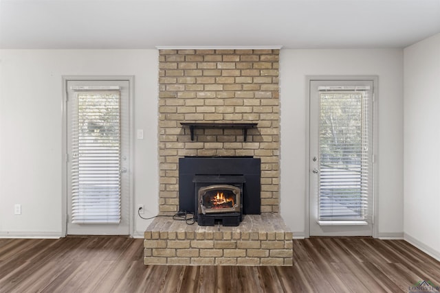 unfurnished living room with hardwood / wood-style flooring and a wood stove