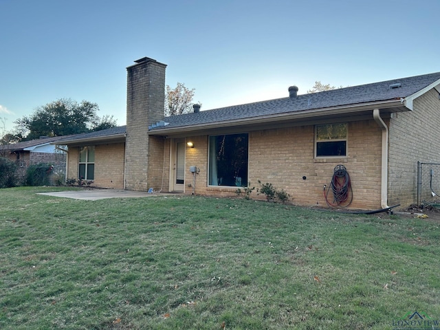 back of house featuring a patio area and a lawn