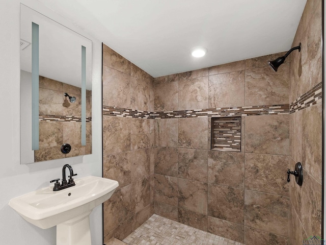 bathroom with a sink and tiled shower
