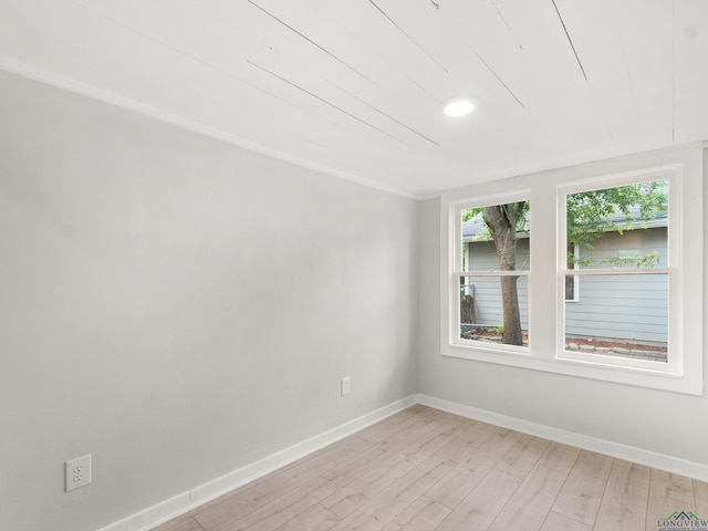 unfurnished room with baseboards and light wood-style flooring