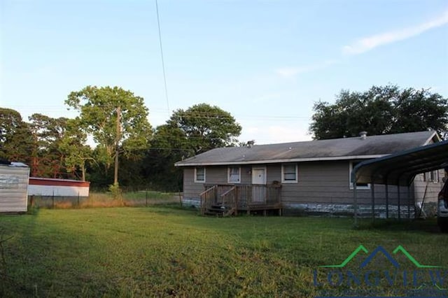 back of house with a lawn and a carport