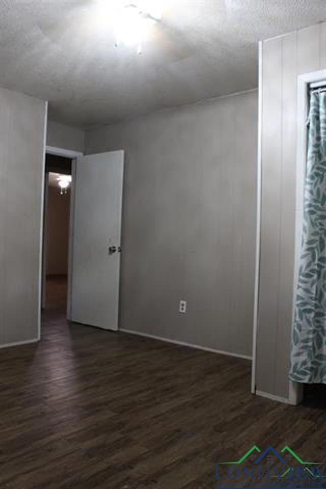 spare room featuring dark wood-type flooring