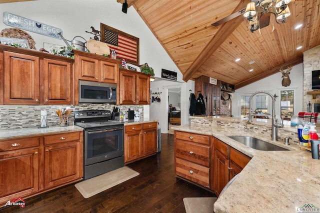 kitchen featuring sink, decorative backsplash, vaulted ceiling with beams, and appliances with stainless steel finishes