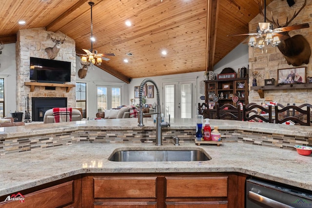 kitchen with sink, wood ceiling, a fireplace, light stone countertops, and stainless steel dishwasher