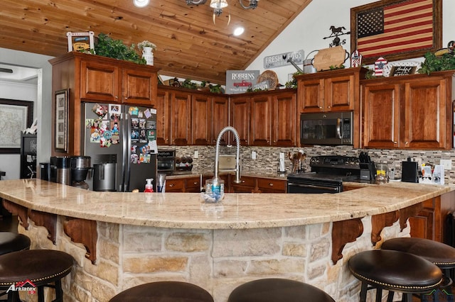 kitchen featuring wood ceiling, stainless steel appliances, a kitchen breakfast bar, decorative backsplash, and vaulted ceiling