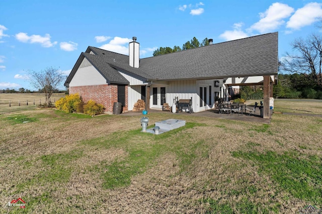 back of property with a lawn and a patio area