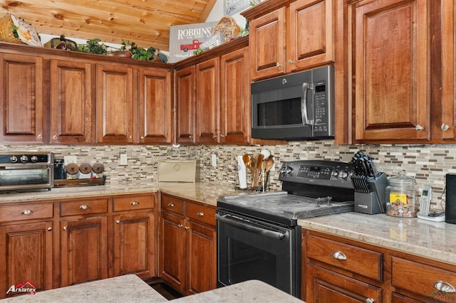 kitchen featuring tasteful backsplash, light stone countertops, and black appliances