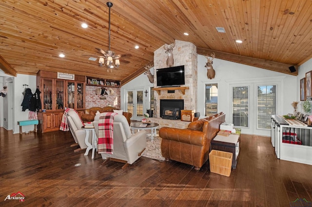 living room with dark hardwood / wood-style flooring, wood ceiling, a stone fireplace, and beamed ceiling