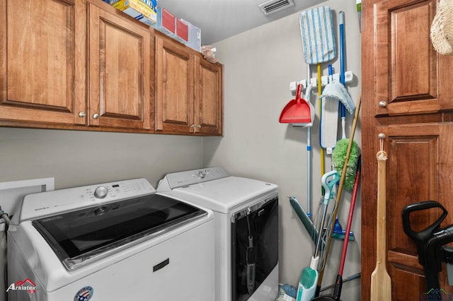 washroom with cabinets and washing machine and dryer