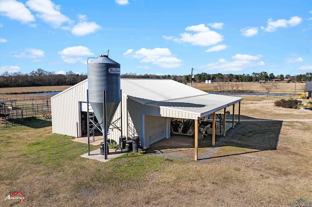 view of outbuilding with a garage, a yard, and a rural view