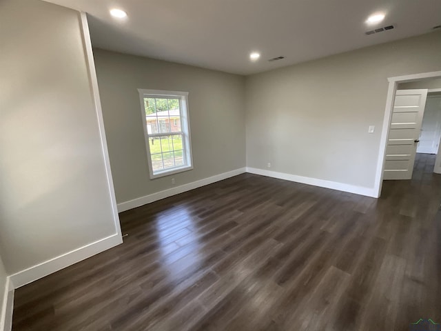 spare room featuring baseboards, visible vents, dark wood-style floors, and recessed lighting