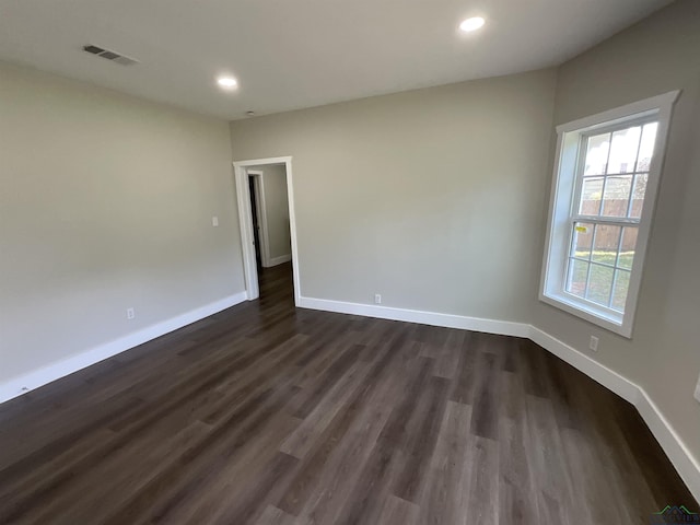 empty room with visible vents, recessed lighting, dark wood-style floors, and baseboards