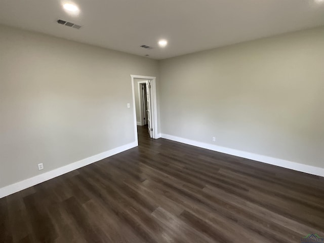 empty room featuring visible vents, recessed lighting, dark wood finished floors, and baseboards