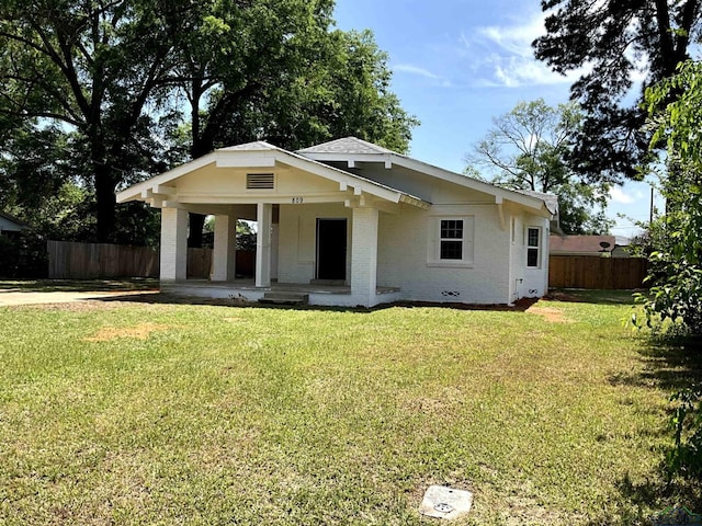 bungalow-style home with a porch, a front yard, brick siding, and fence