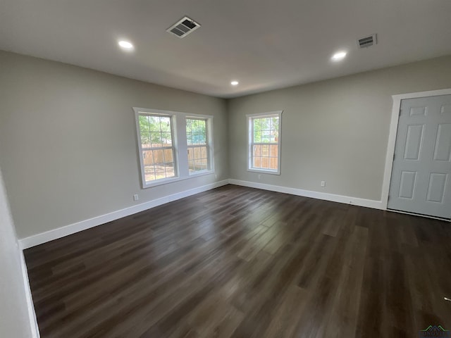 spare room with baseboards, visible vents, dark wood finished floors, and recessed lighting