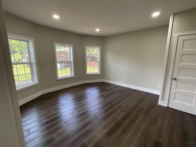 empty room with baseboards, recessed lighting, and dark wood-type flooring