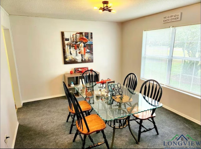 dining area featuring a textured ceiling and dark colored carpet