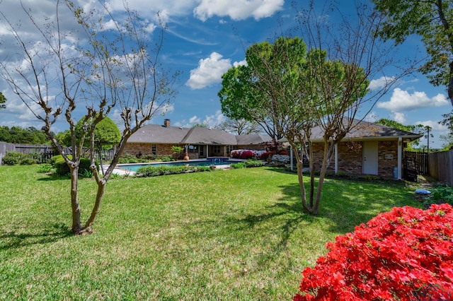 view of yard with fence and a fenced in pool