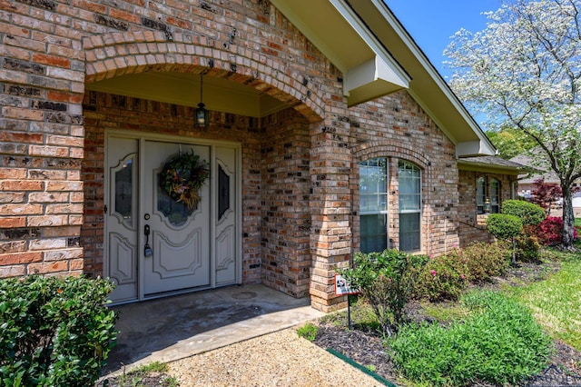 entrance to property featuring brick siding