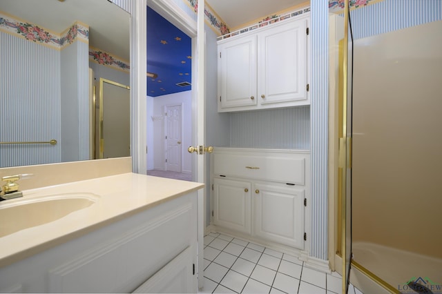 full bath featuring tile patterned flooring, vanity, wallpapered walls, and a stall shower