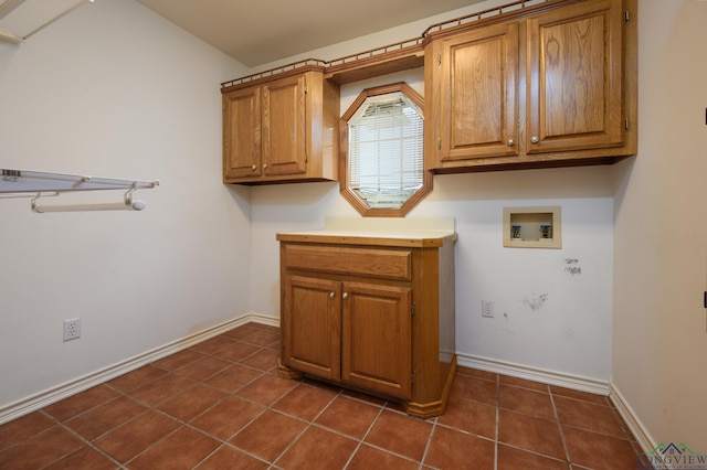 laundry room featuring baseboards, dark tile patterned floors, hookup for a washing machine, and cabinet space