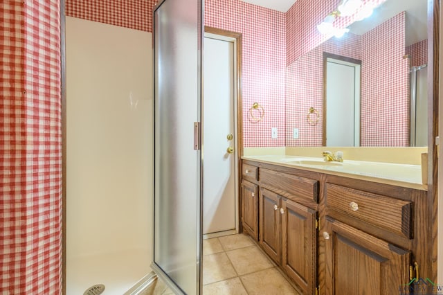 full bath with tile patterned floors, vanity, wallpapered walls, and a stall shower